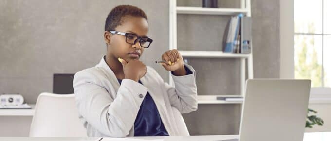 African American Woman Looking Seriously at her Laptop