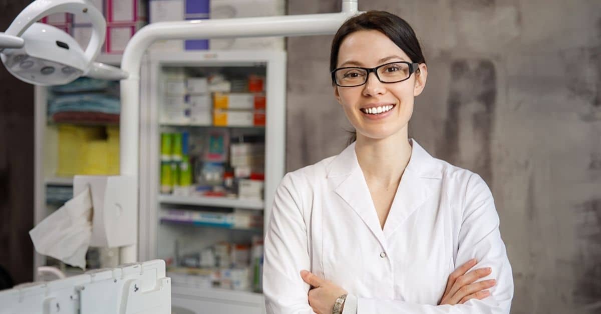 Woman with Arms Crossed Posing for Camera Smiling in a Medical Setting