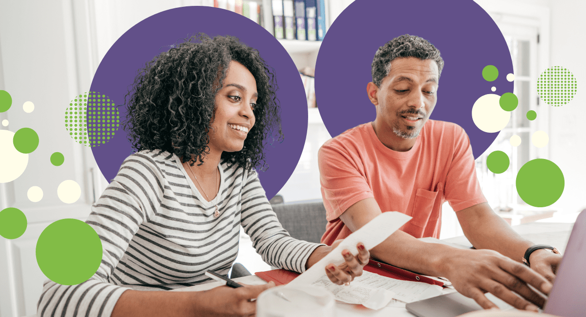 couple working on paperwork and laptop, slight smile on their faces