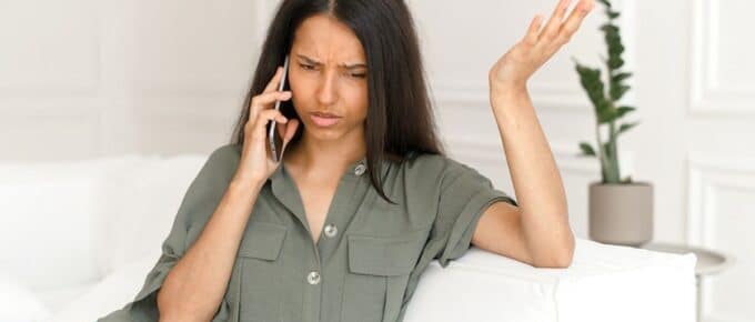 Woman with Hand in the Air in Confusion While on Cellphone Call