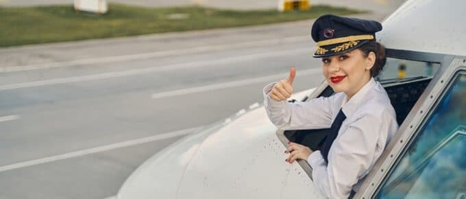Female Pilot in Plane Giving a Thumbs Up from Open Window