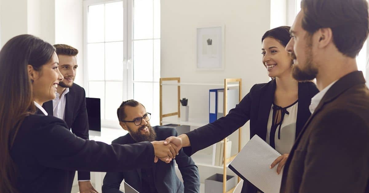 Group of People with Two Women in Professional Wear Shaking Hands Smiling