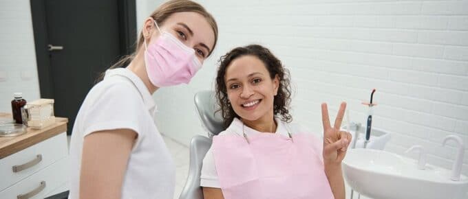 a dentist and patient smiling in a dental office