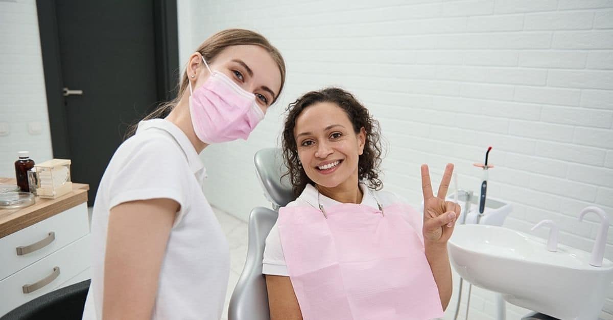 a dentist and patient smiling in a dental office