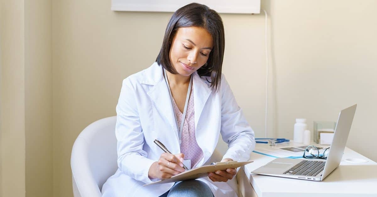 African American in White Coat Taking Notes