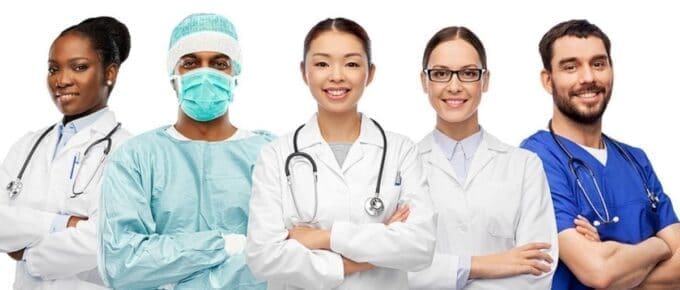 group of health care professionals in gowns smiling