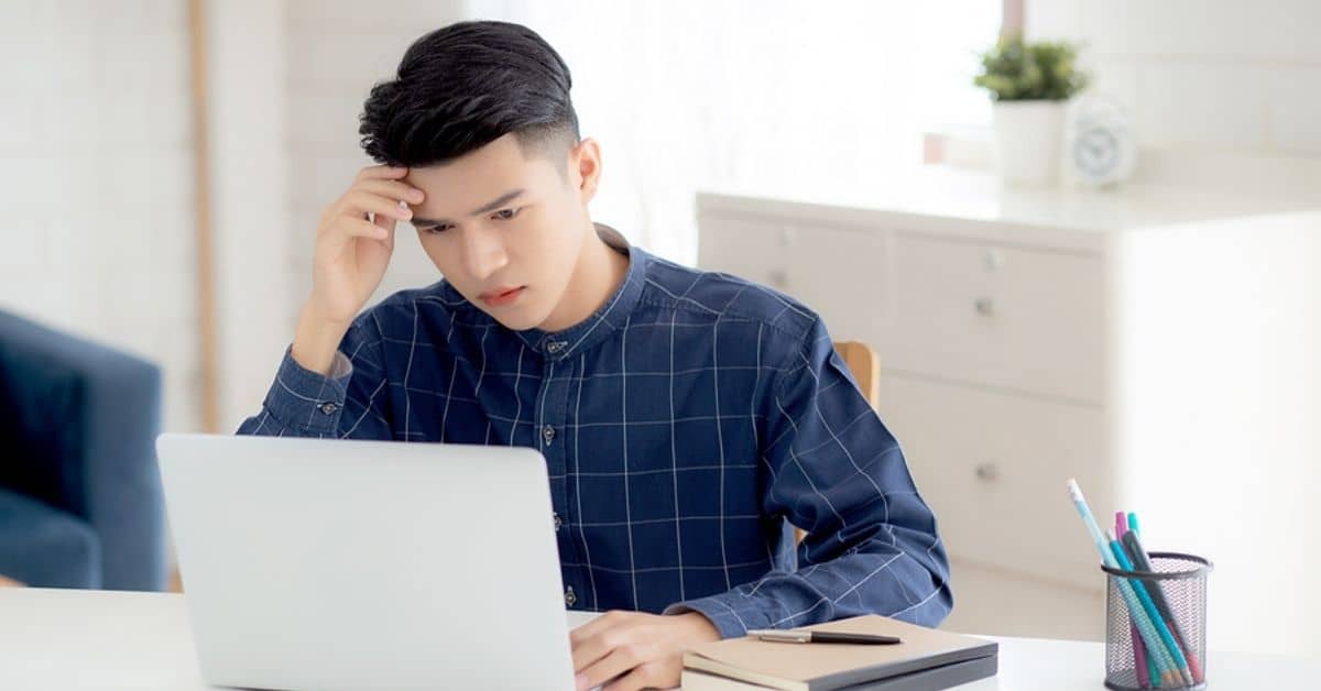 Young asian business man headache during working on laptop computer