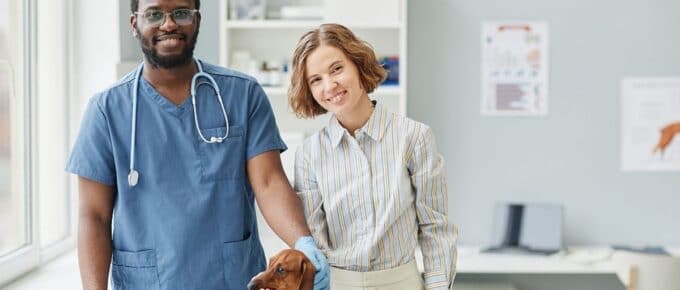 2 veterinarians standing in office with dog
