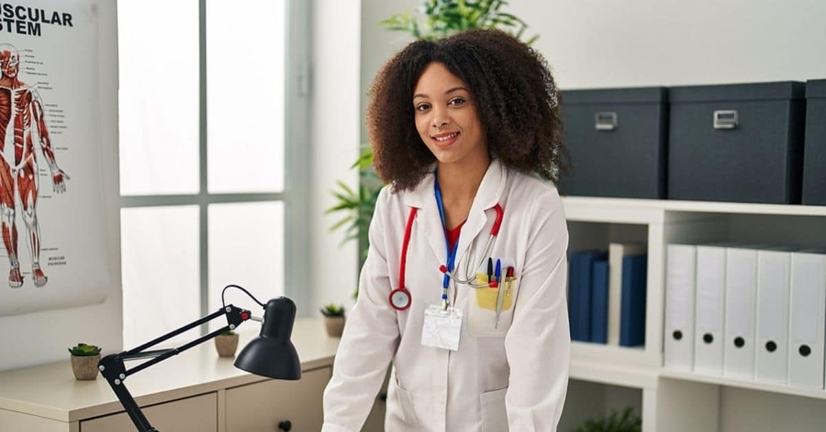 Young african american woman wearing doctor uniform standing at clinic