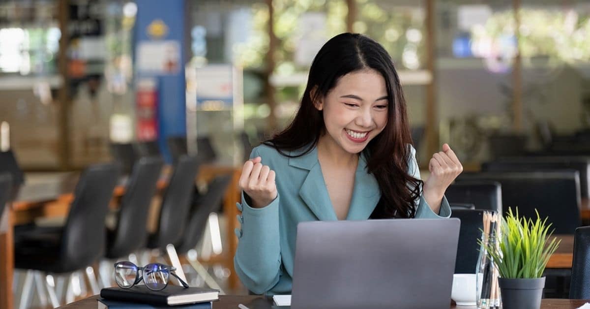 Beautiful Asian woman celebrate with laptop, success happy pose