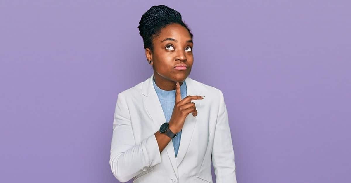 Young african american woman wearing business clothes thinking concentrated about doubt with finger on chin and looking up wondering