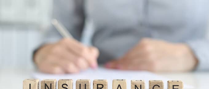 Insurance agent fills out insurance form in office.