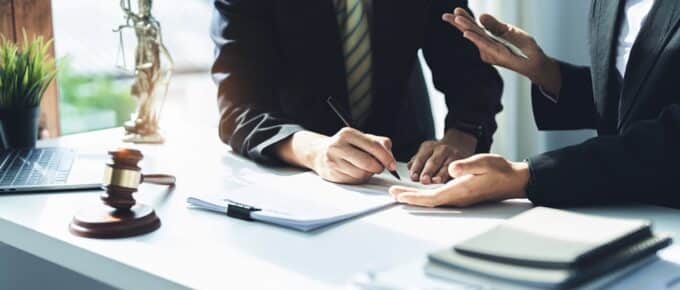 Lawyer holding a pen is consulting with a client to explain the pattern of answering questions before going to court to decide a lawsuit.