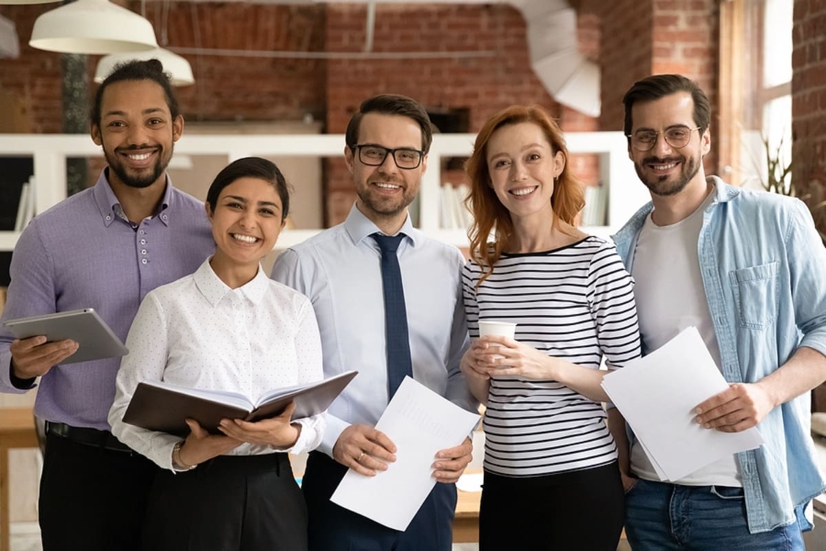 Portrait of smiling multiethnic colleagues pose in office