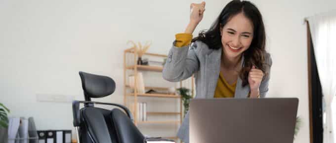 Happy excited asian woman celebrate with computer