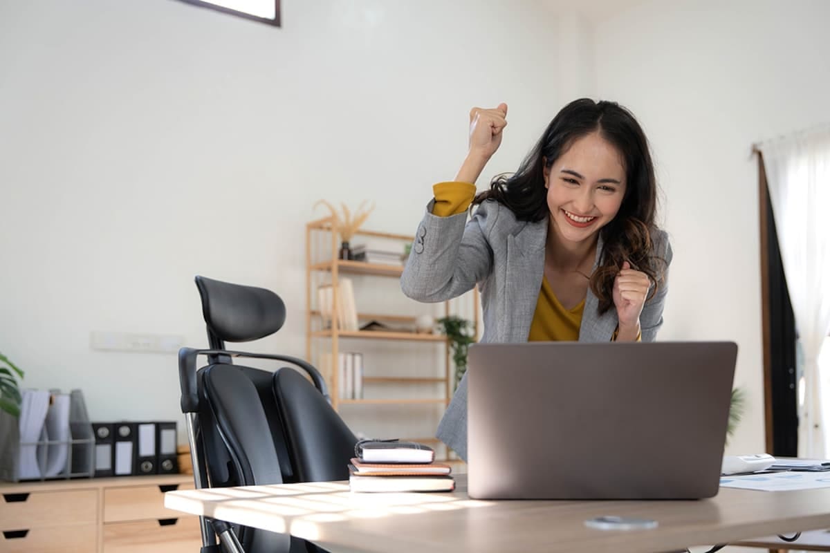 Happy excited asian woman celebrate with computer