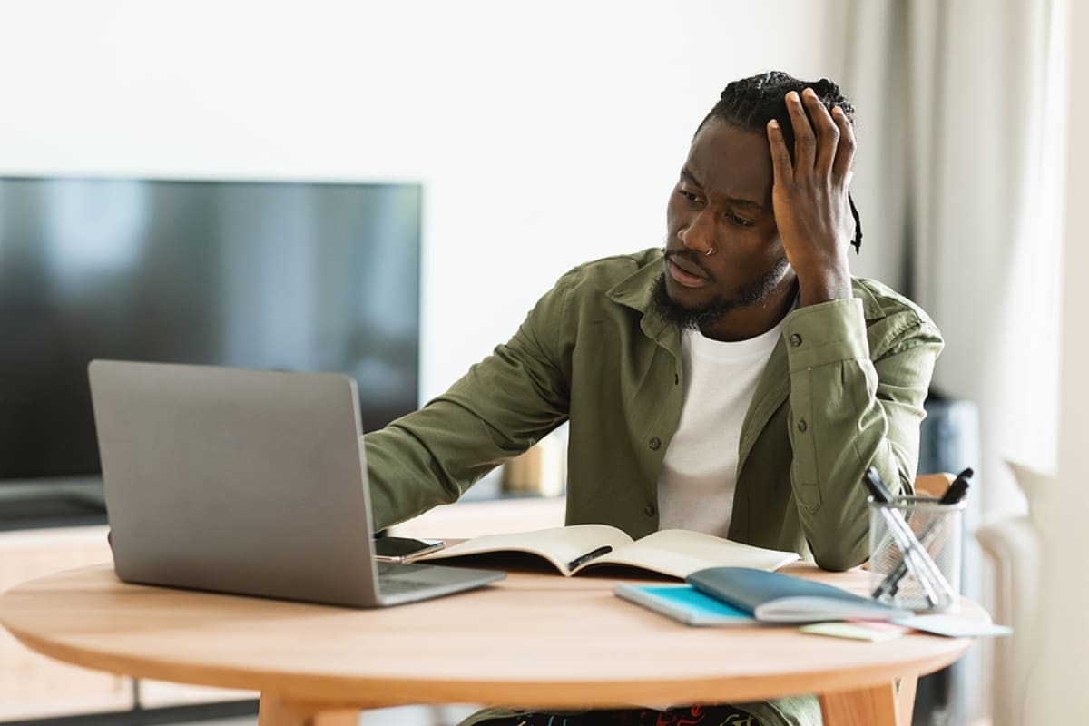 Thoughtful black man using laptop computer