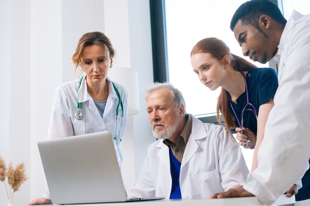 Diverse team of multi-ethnic doctors in meeting planning and brainstorming in boardroom using laptop