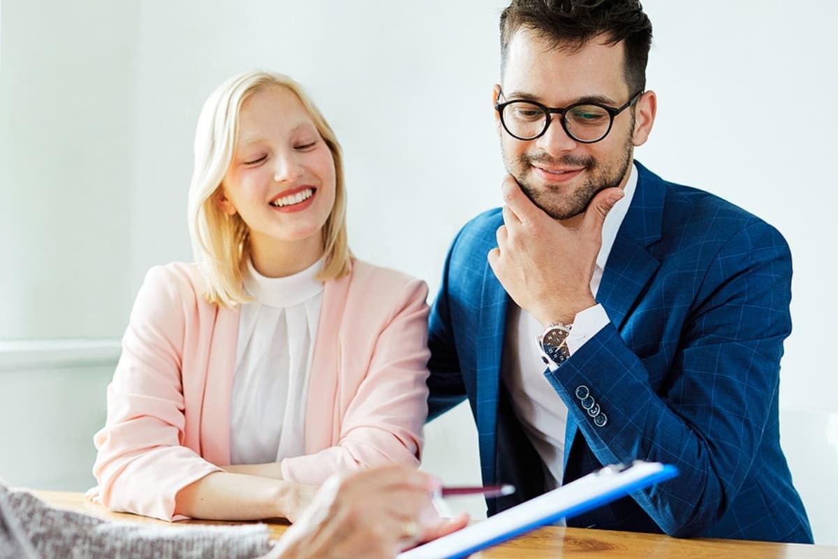 Young couple sitting at a desk reviewing disability insurance documents.