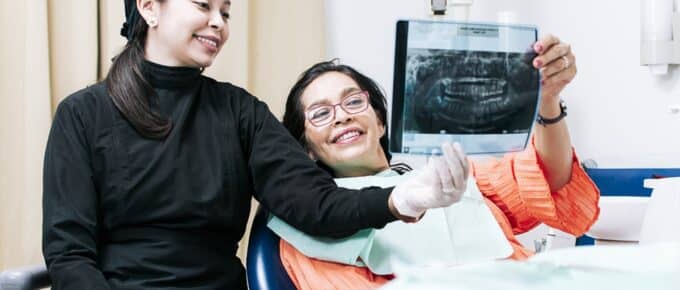 Endodontist reviewing xrays with a patient in a dental office.