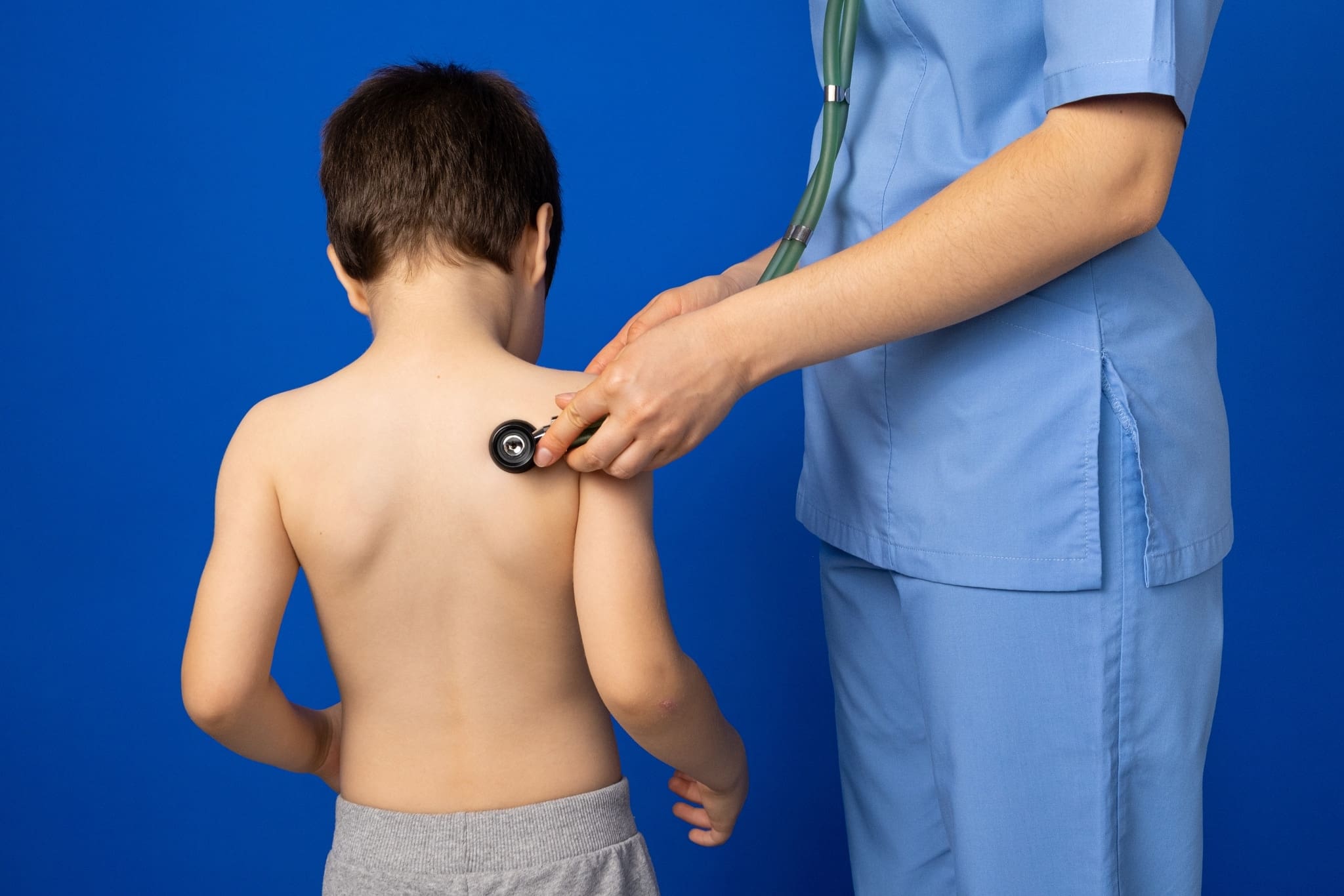 The doctor listens to the heart and lungs of a 5-year-old boy with a stethoscope.