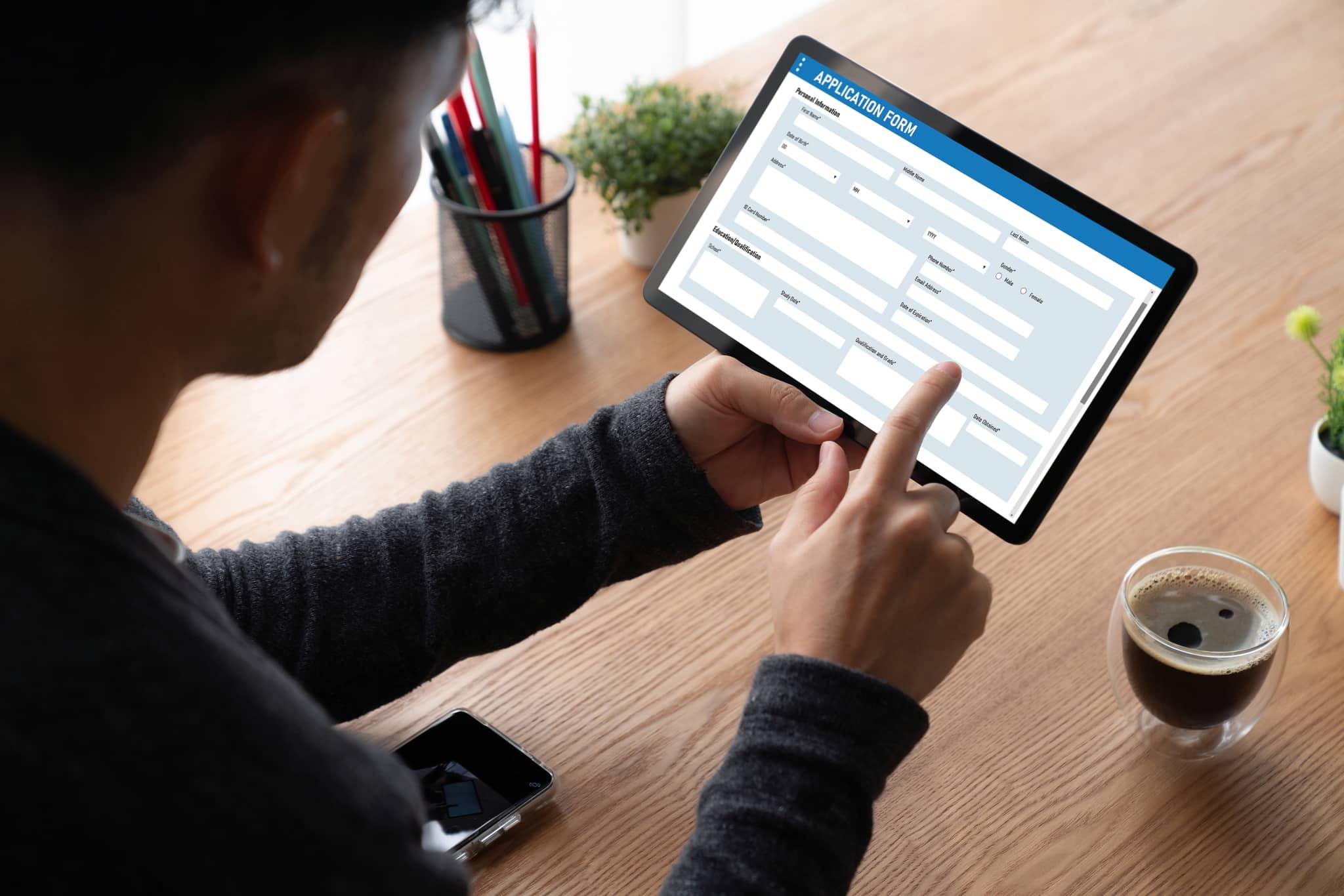 Online application form on an iPad while a man is holding the tablet.