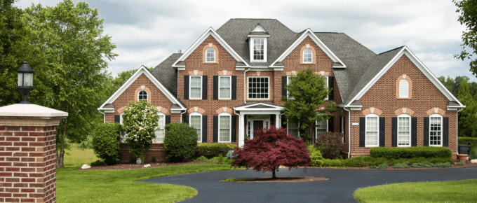 large brick home with manicured lawn.