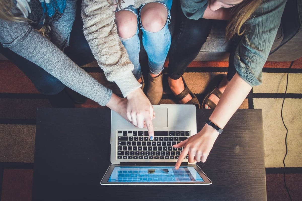 Parents and student pointing to laptop to look at how to pay for college