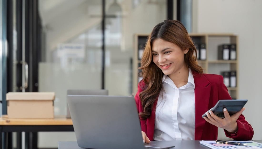 Accountant woman working with calculator and laptop computer