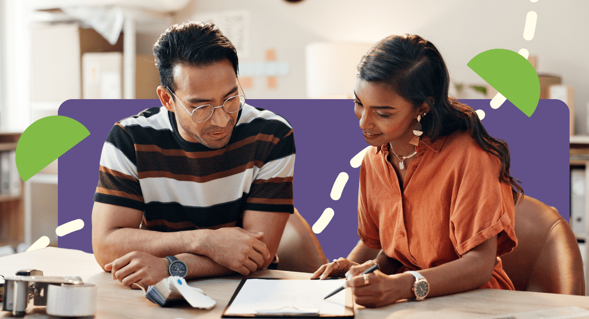 married couple working on paperwork sitting on table in living room