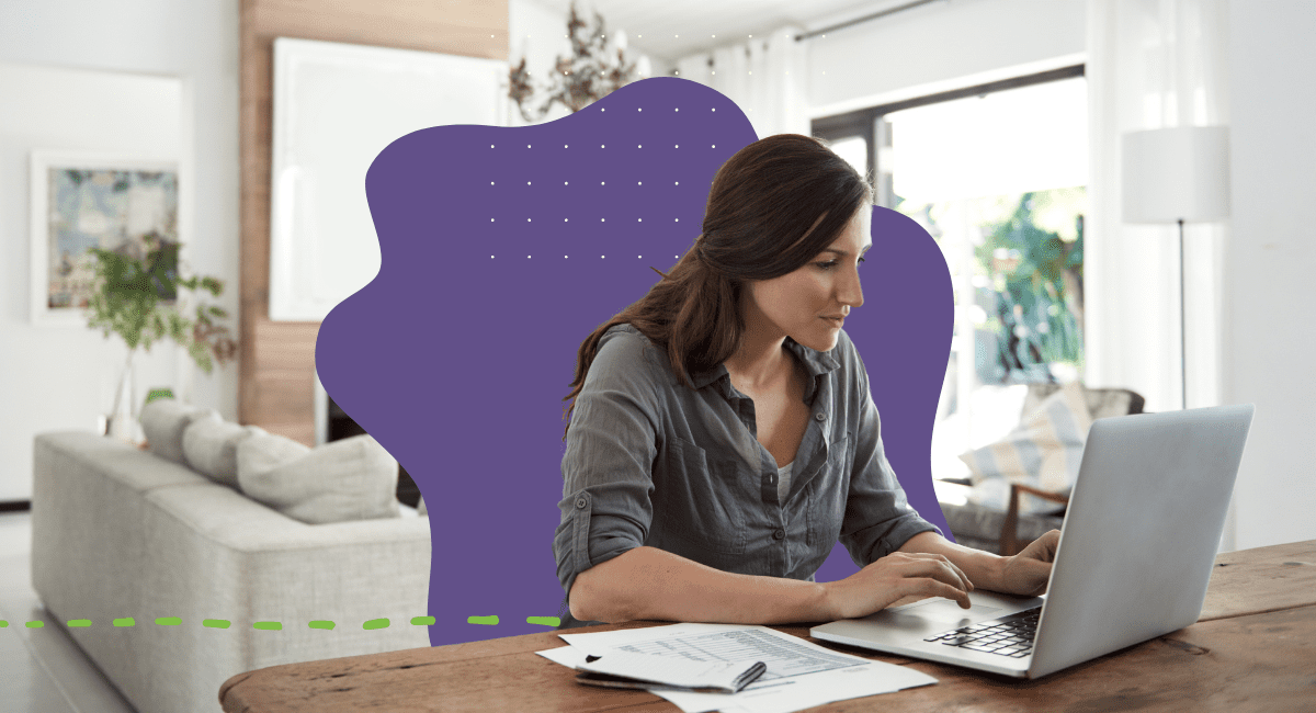 female working on laptop with papers on table