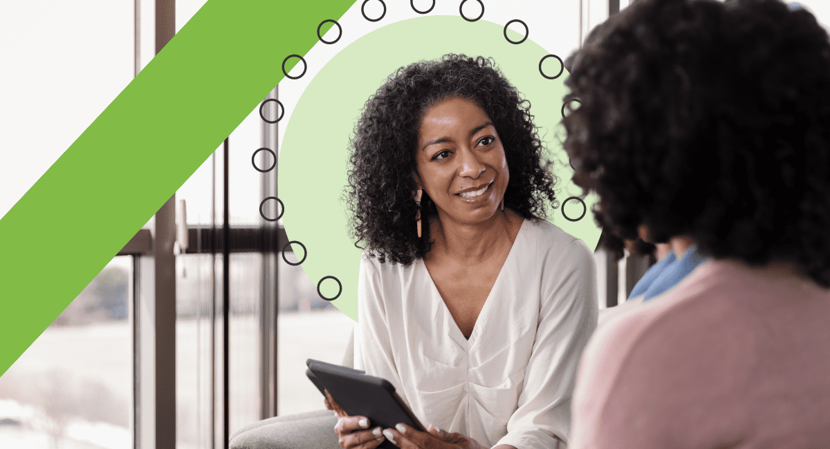 A woman talking to another woman sitting down.