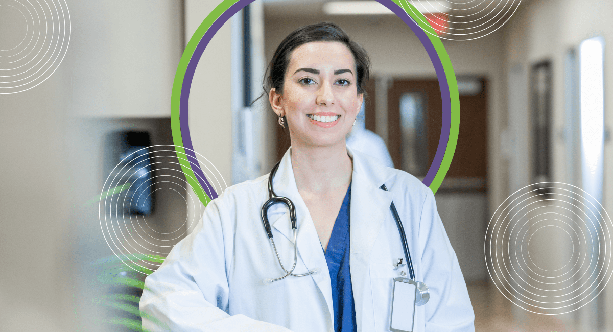 female nurse practitioner smiling, wearing stethoscope, in hospital setting