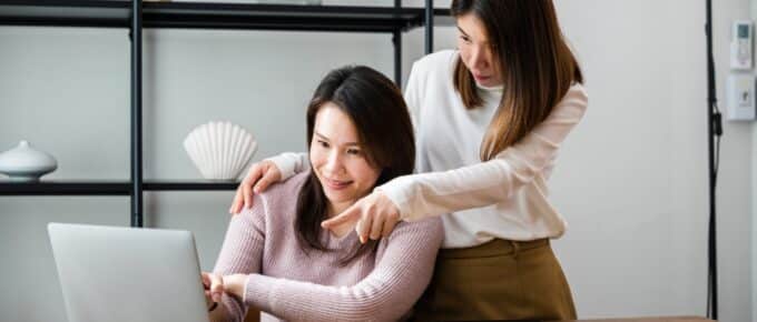 Asian middle age woman and teen looking at colleges and pelf on computer