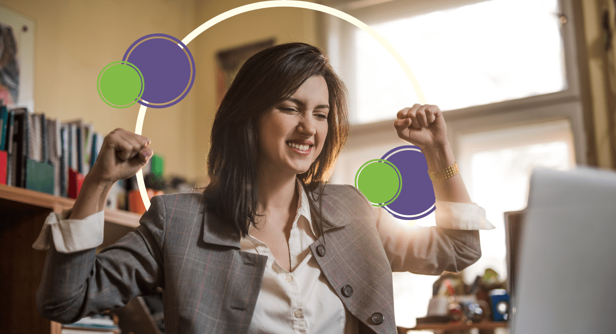 female office worker cheering in joy looking at laptop