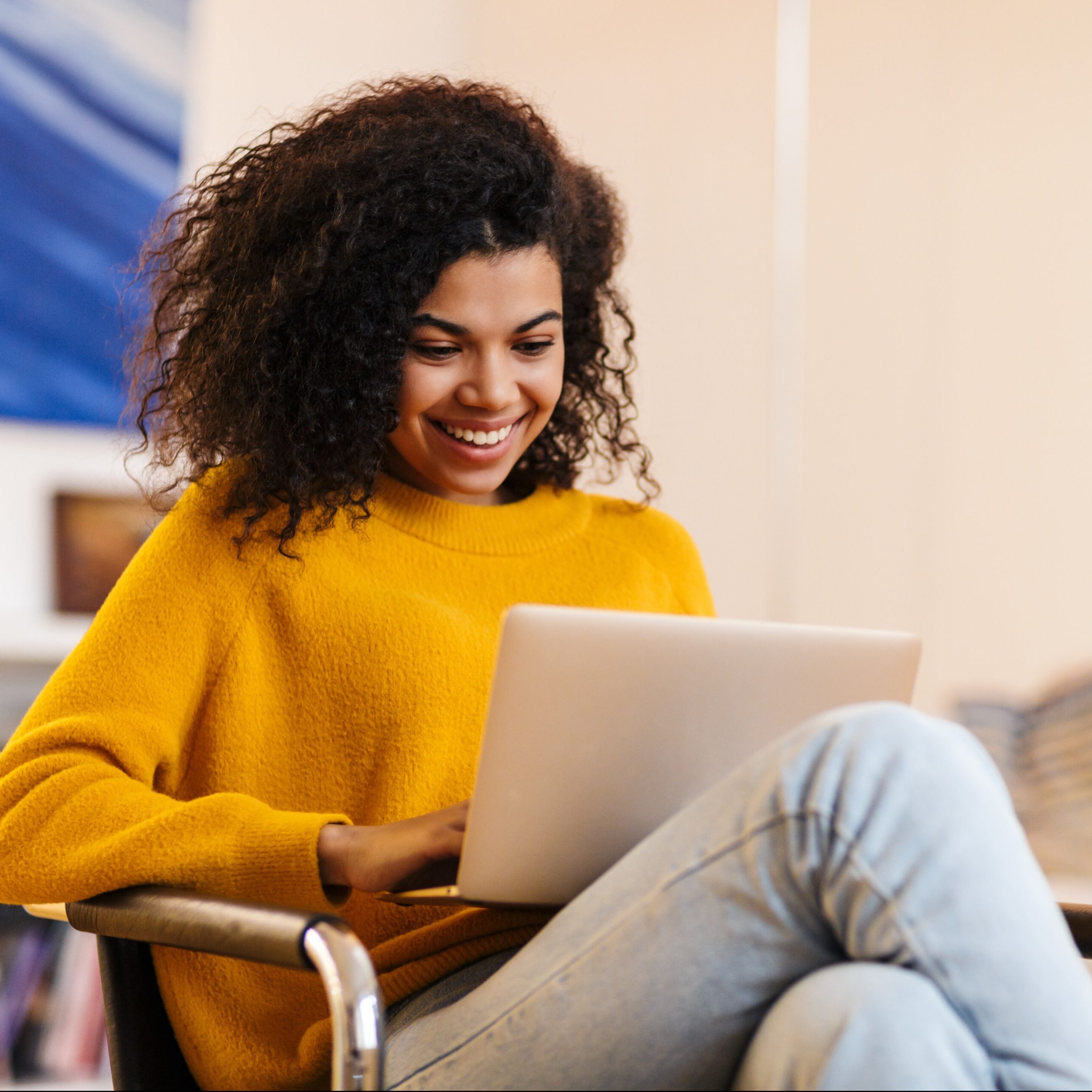 Young Black woman in yellow sweater taking student loan refinancing quiz.