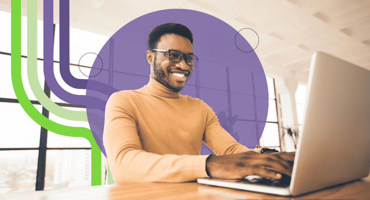 A man smiling while working on his computer