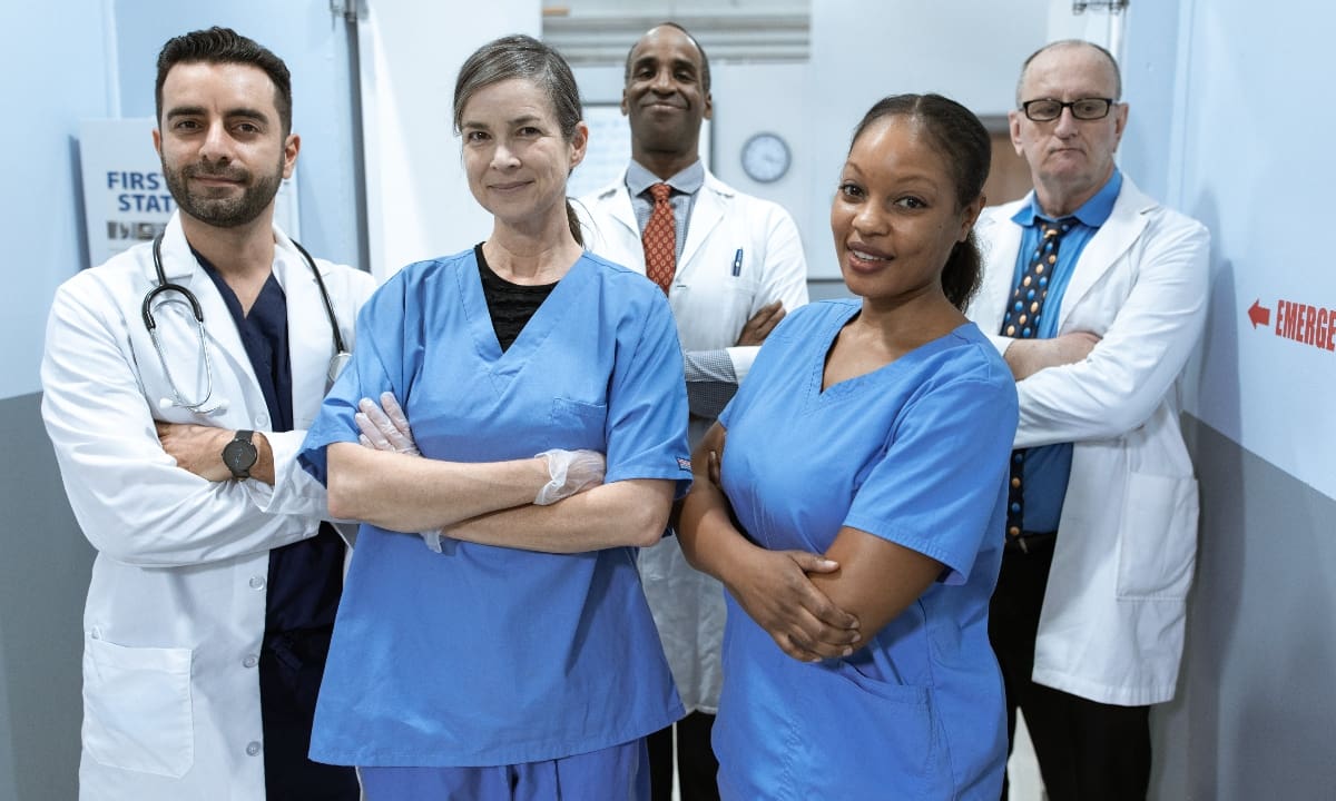 group of medical professionals, two doctors and two nurses, standing in a hallway of an emergency department