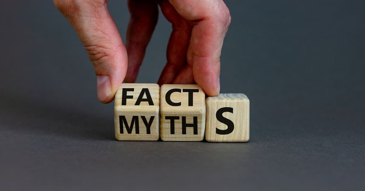 Businessman hand turns cubes and changes the word 'myths' to 'facts'.