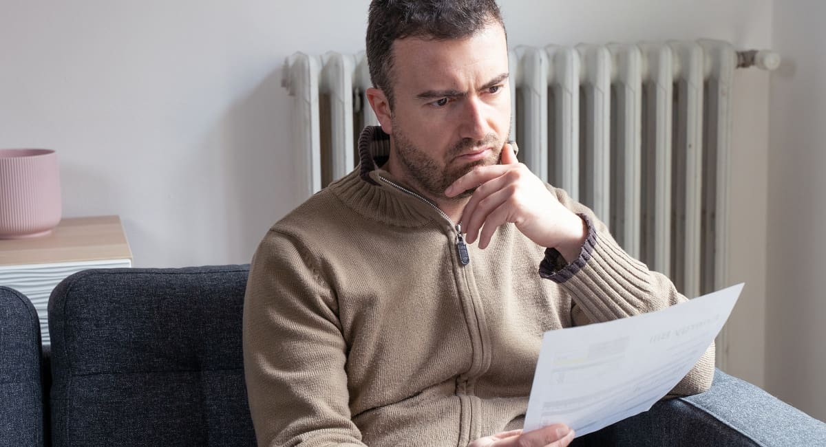 Shocked man reading some documents on sofa living room