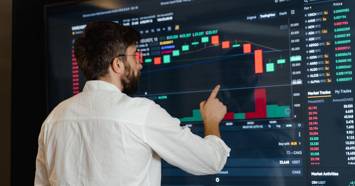 Man in White Dress Shirt Analyzing Data Displayed on Screen