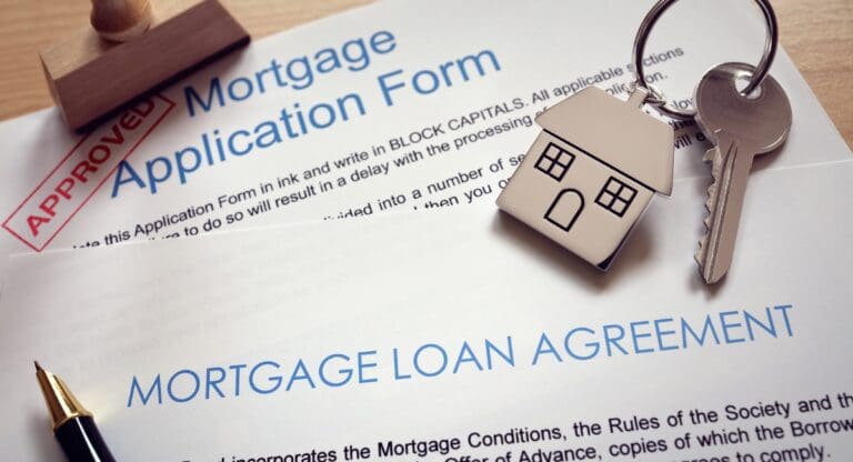 Mortgage loan agreement application with key on house shaped keyring