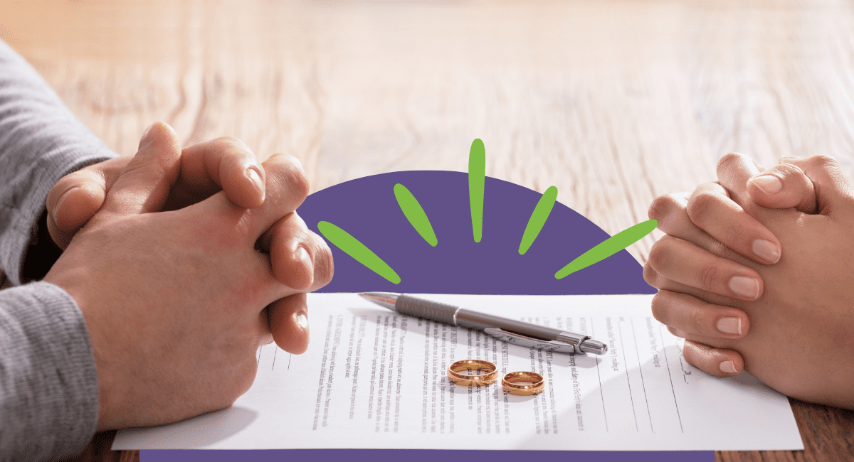 two people's hands on table with divorce paper and two rings in the middle