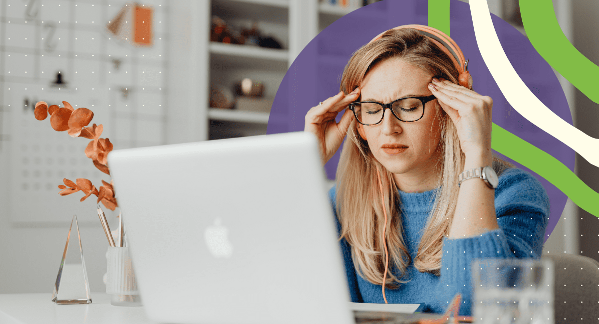 woman with glasses on, looking at her laptop, under a lot of stress