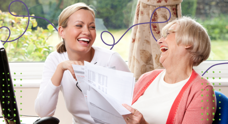 Woman and her mother sitting outside reviewing documents and smiling