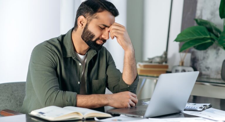 Man sitting at desk looking worried