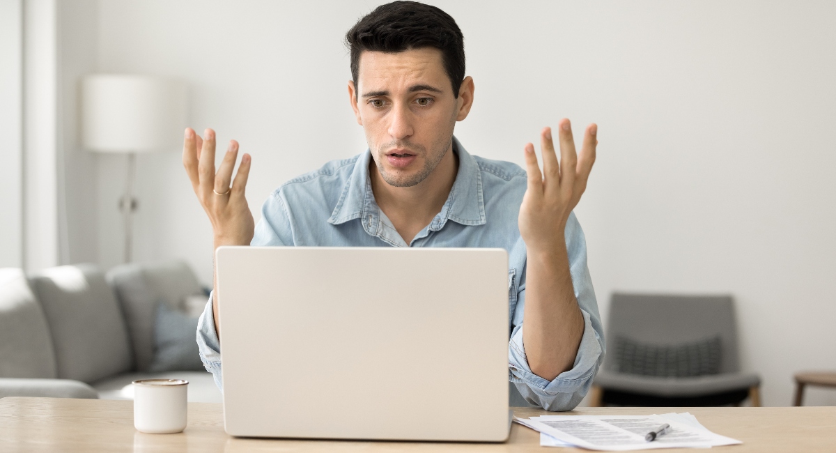 Confused man looking at laptop