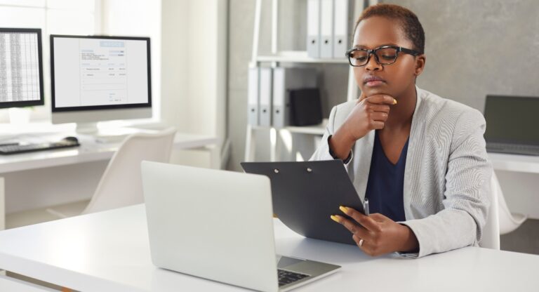 Black woman reading documents and thinking sitting at office
