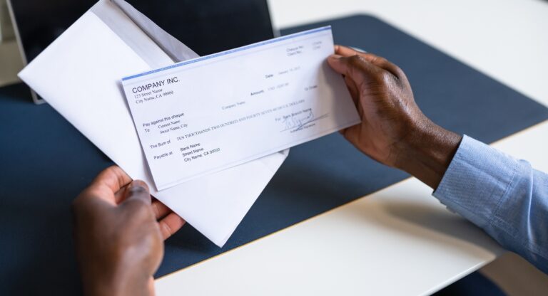 Man holding paycheck in his hand