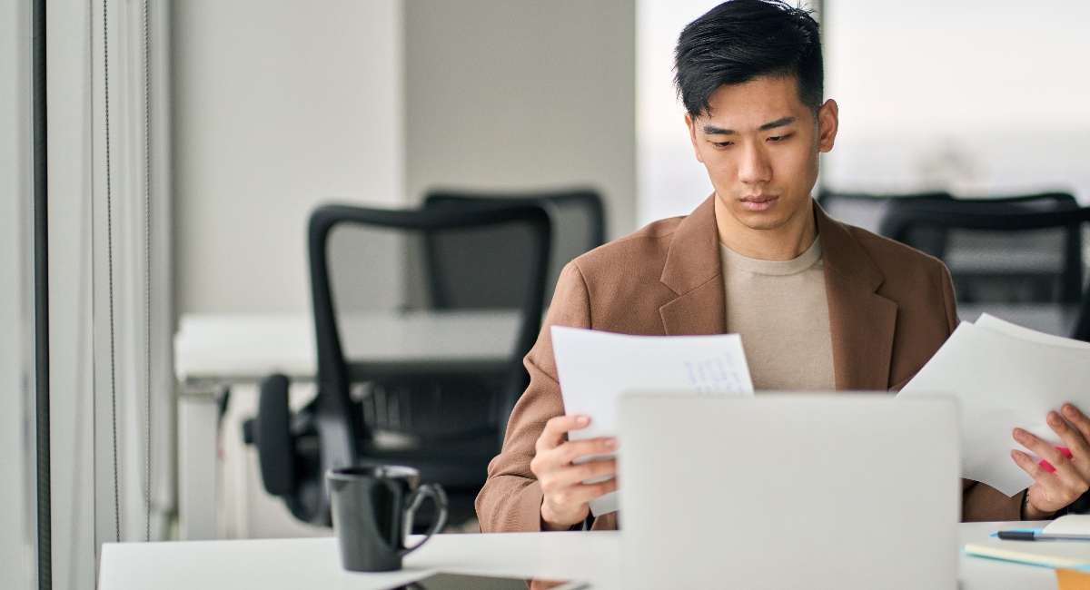 Professional business man sitting at desk in office reviewing documents